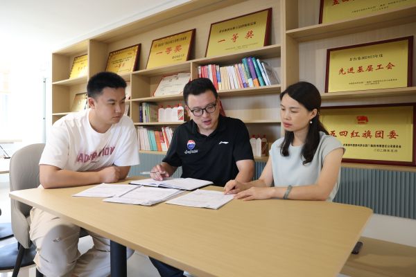 代文祥梓与同事一起讨论工作